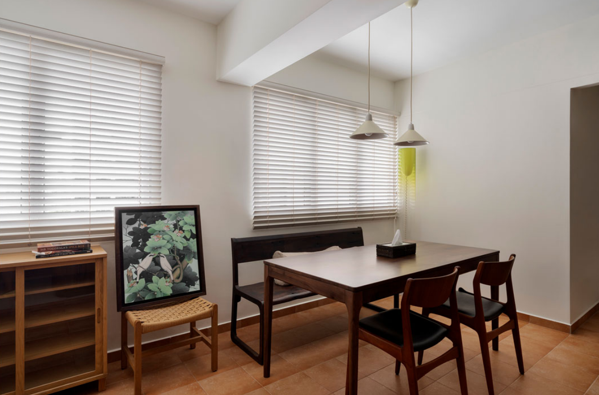 Dining area with a wooden table, bench and pendant lights in the Cantonment Close flat
