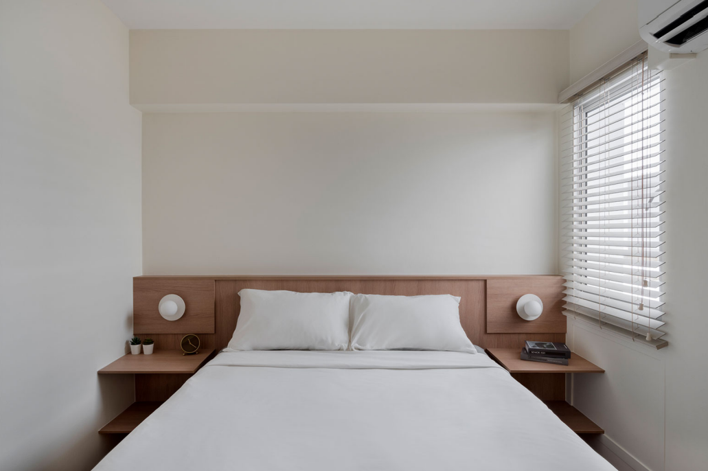 Minimalist master bedroom with a wooden headboard and built-in bedside shelves