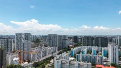 Highrise residential blocks with construction crane against a blue sky with white clouds