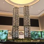 Scale model of Zyon Grand residential towers displayed in a sales gallery with seating area