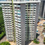 Two high-rise residential blocks near a large park and construction site along a road
