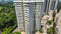Two high-rise residential blocks near a large park and construction site along a road