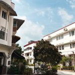 Two white conserved residential buildings with red street number signs at 57 Eng Hoon Street and 58 Seng Poh Road