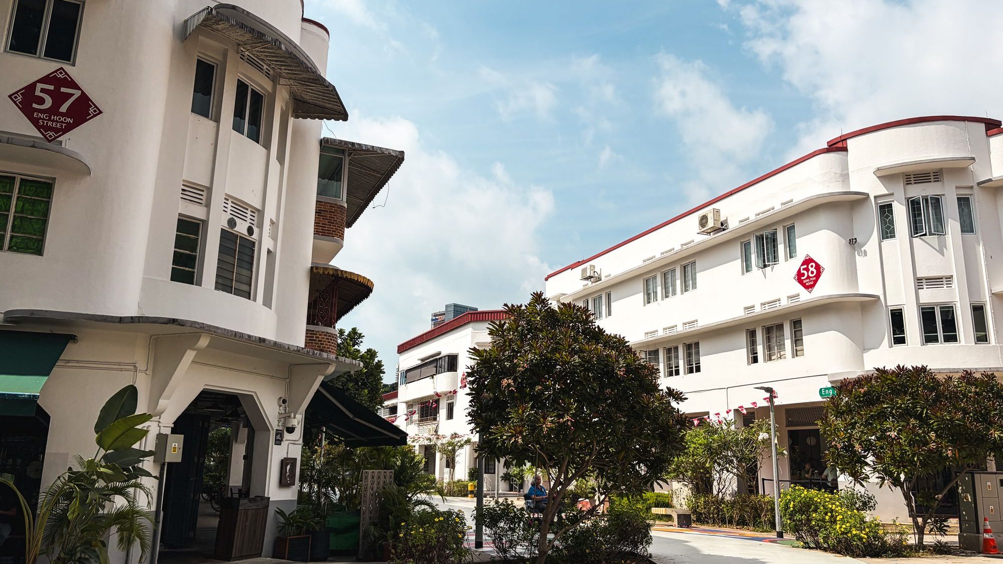 Two white conserved residential buildings with red street number signs at 57 Eng Hoon Street and 58 Seng Poh Road