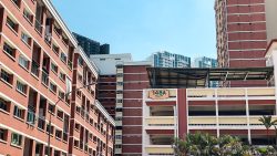 Red and white HDB blocks at 148A Mei Ling Street with tropical greenery under blue sky