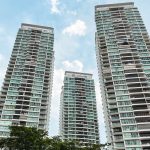 Natura Loft Bishan DBSS apartment blocks with balconies against a blue sky and trees in foreground