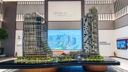 Two detailed architectural models of Union Square Residences towers with surrounding greenery and digital cityscape backdrop