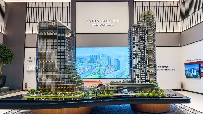 Two detailed architectural models of Union Square Residences towers with surrounding greenery and digital cityscape backdrop