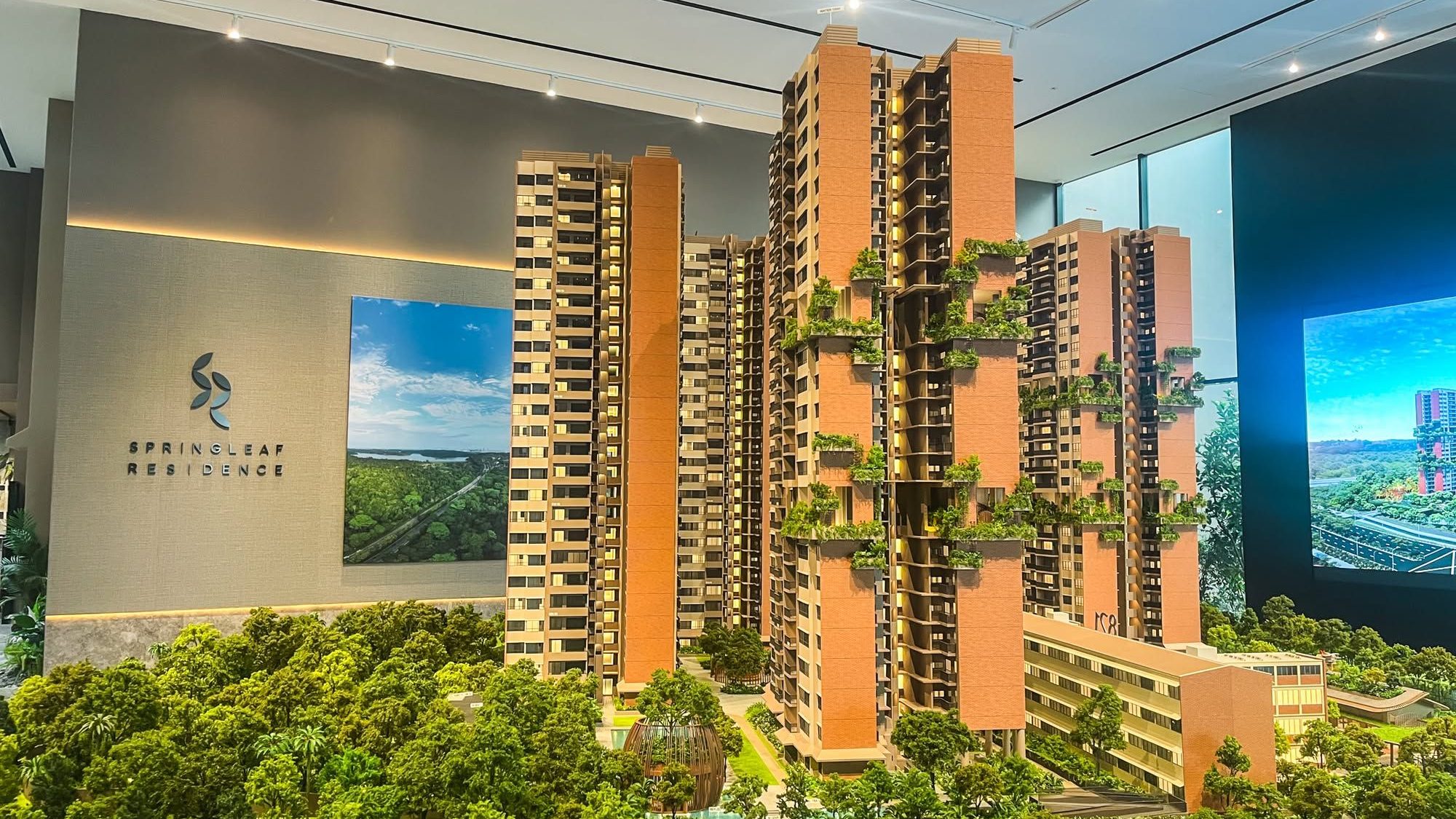 Scale model of Springleaf Residence apartment blocks with greenery and interior showroom backdrop