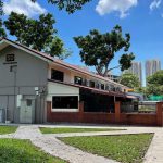Single-storey terrace house with red brick wall and pitched roof at 50 Stirling Road amid trees and walkway
