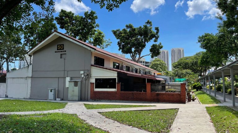 Single-storey terrace house with red brick wall and pitched roof at 50 Stirling Road amid trees and walkway