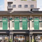 Shophouse facade with green and blue shutters above cafes named Sushi Corner, Montresor, and Bistro
