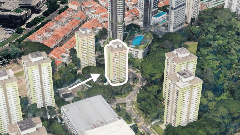 High-rise HDB residential blocks around a green wooded area, with one block marked by a white outline and arrow