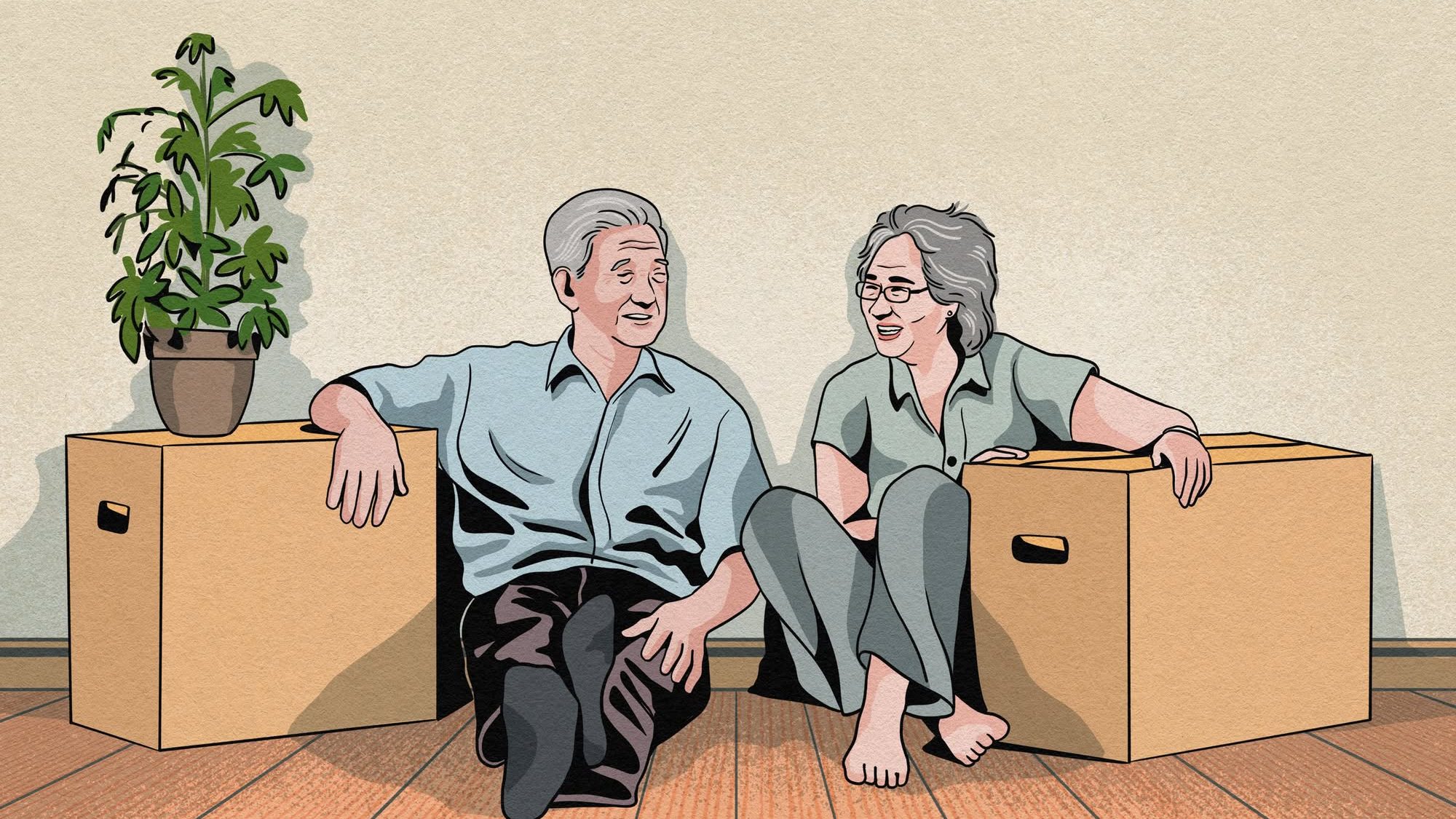 Elderly couple sitting on floor between two moving boxes, one with a potted plant on top