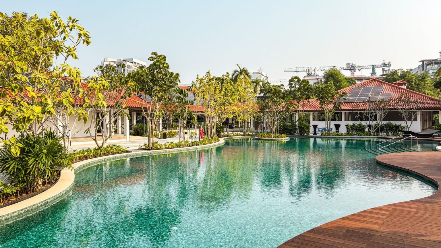Swimming pool with landscaped garden and red-tiled roof pavilion in a residential development