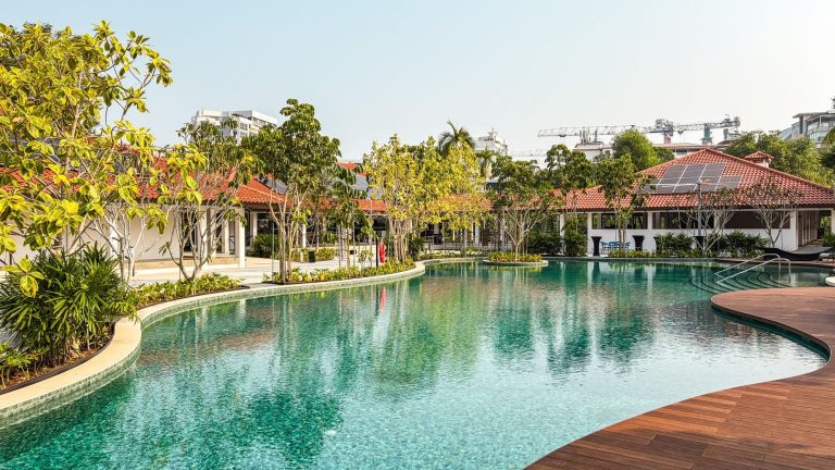 Swimming pool with landscaped garden and red-tiled roof pavilion in a residential development