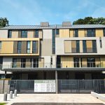 Modern landed homes with wooden panel exterior and gated entrance surrounded by trees