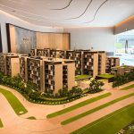 Scale model of Amberwood residential blocks with greenery and walking paths in an indoor showroom setting