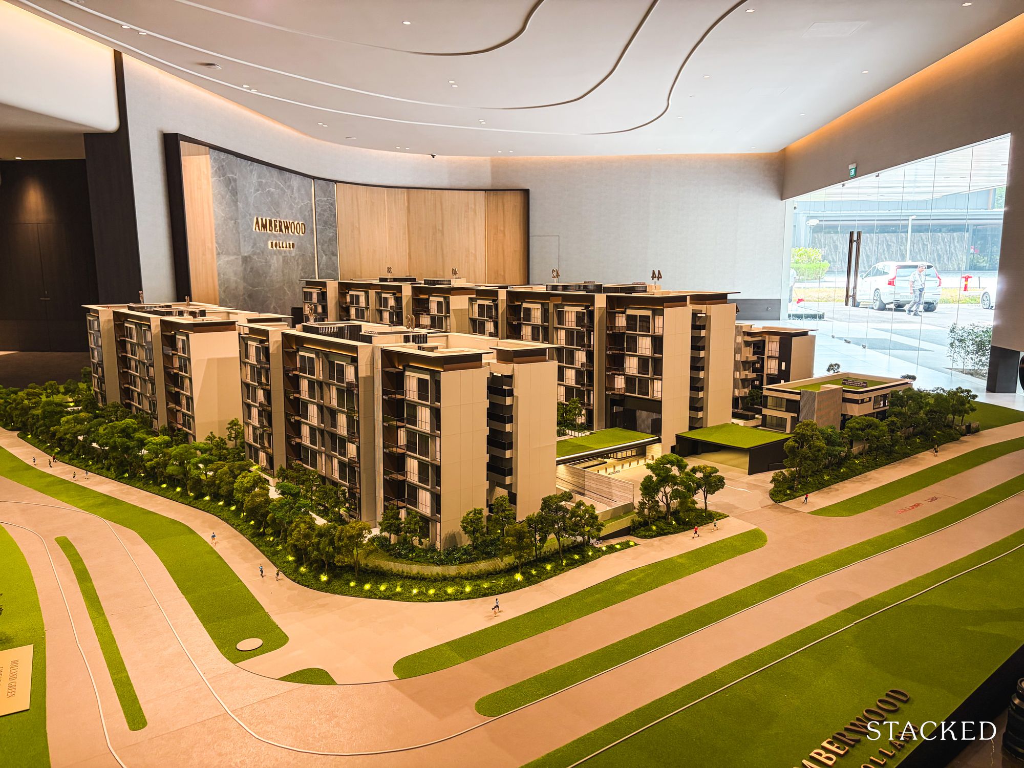 Scale model of Amberwood residential blocks with greenery and walking paths in an indoor showroom setting