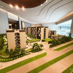 Architectural model of a residential development showing buildings, greenery, paths and a running track in a showroom