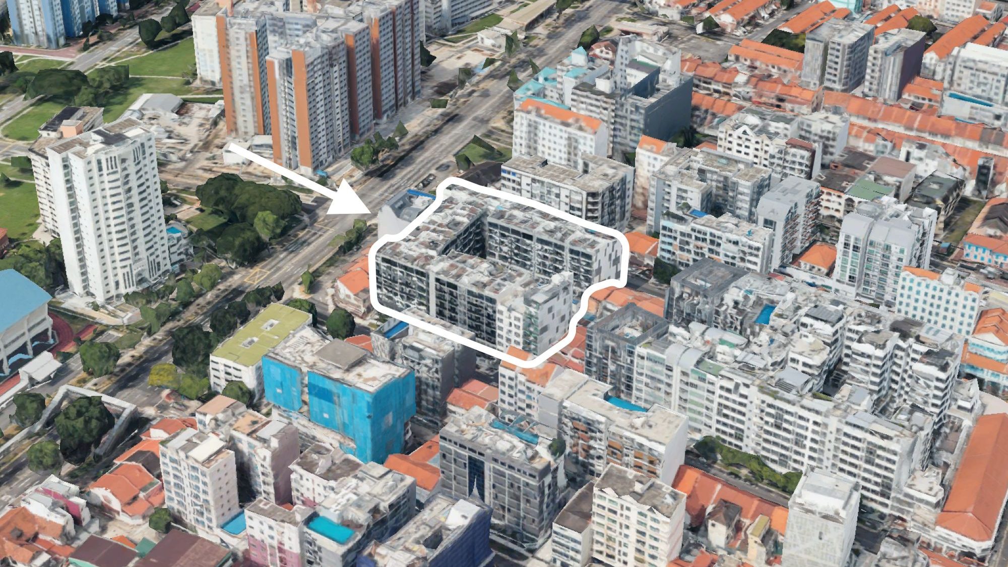 Aerial view of dense residential blocks with one block outlined and highlighted by an arrow