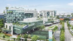 Plaza 8 commercial buildings with glass facades, rooftop greenery, and a sports court in a business park setting