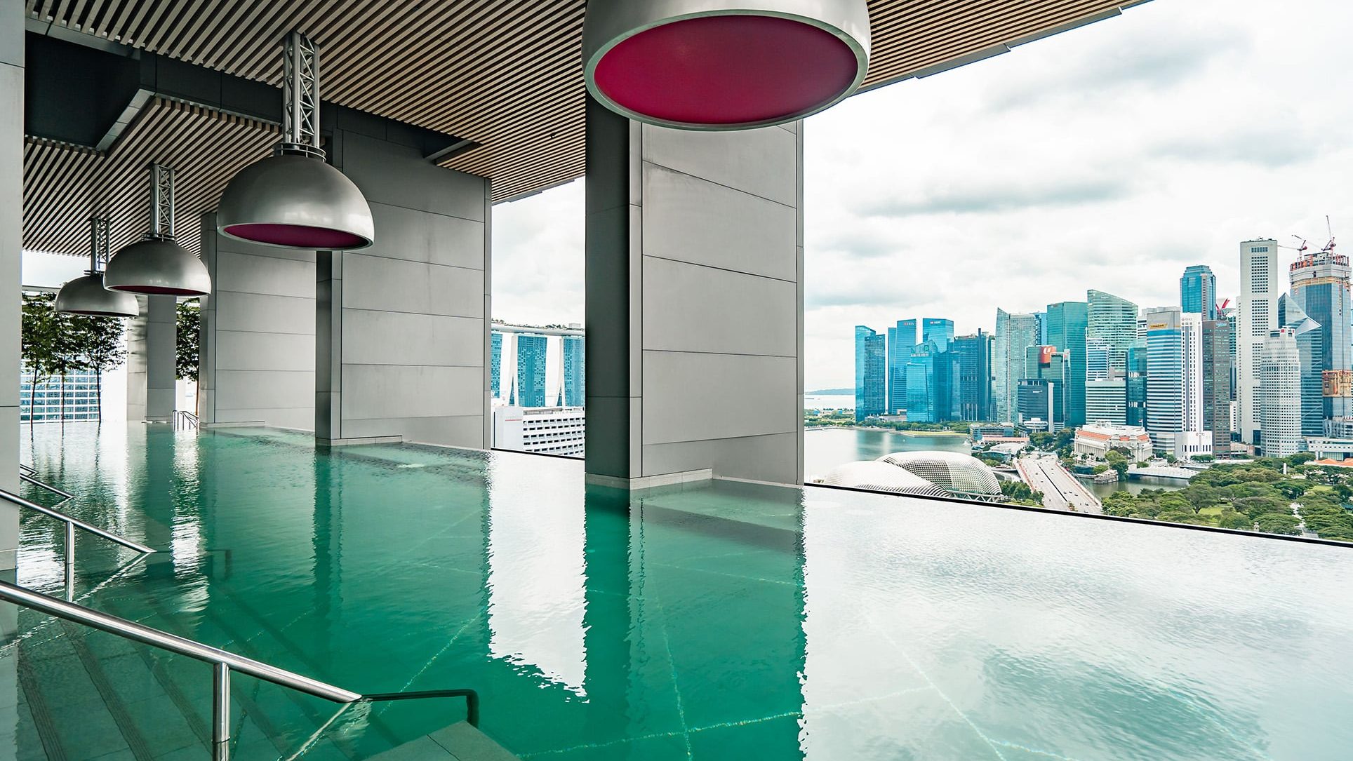 Infinity pool at South Beach Residences with a view of the city skyline and Marina Bay Sands in the background