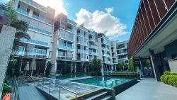 Robin Residences apartment blocks with swimming pool, sun loungers and landscaped greenery under a blue sky