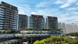 Waterway Point retail mall with residential blocks behind under a partly cloudy blue sky
