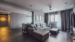 Living room with grey sectional sofa, coffee table, ceiling fan, TV, and adjacent dining area with chairs and table