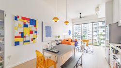 Dining table with mixed chairs beside an orange sofa and glass sliding doors in a living room