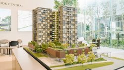 Model of Sky Eden@Bedok showing two residential towers with greenery and amenities in a sales gallery setting