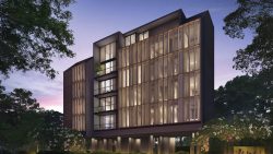 Ikigai apartment block at dusk with lights on inside and surrounded by trees and greenery