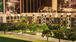 Architectural model of residential apartment blocks with parks and labelled towers in the background