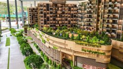 Detailed scale model of Sengkang Grand Residences showing residential blocks and rooftop greenery with pathways and gym equipment