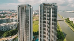 Two tall residential apartment blocks with a canal and cityscape in the background