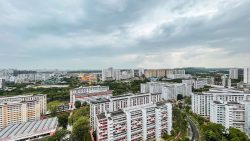 HDB residential blocks surrounded by greenery under a cloudy sky in Ang Mo Kio Court area
