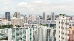 High-rise residential blocks with green rooftops and varied pastel-coloured facades under cloudy sky