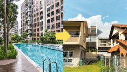 Residential blocks with swimming pool and terrace houses with fenced front yards under blue sky