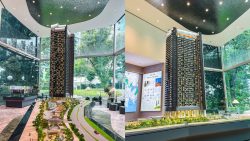 River Green condominium scale model in a sales gallery with glass walls and greenery outside
