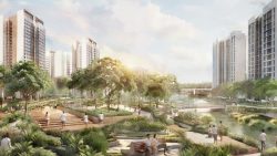 Residential blocks surrounding a landscaped park with walking paths and benches by a waterway