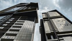 Echelon residential blocks with glass facades and balconies under a cloudy sky