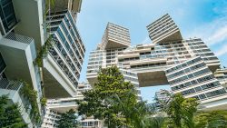 Interlace residential blocks with stacked apartment units and green landscaping under a blue sky