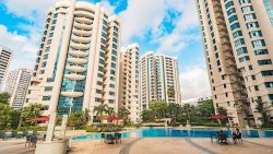 Valley Park apartment blocks with outdoor swimming pool, poolside tables, chairs and red umbrellas