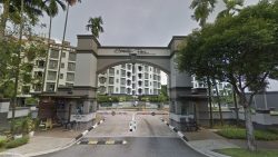 Entrance archway to Serenity Park residential blocks with security post and lush greenery surrounding the driveway