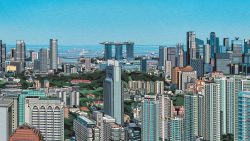 High-rise office towers and residential buildings with Marina Bay Sands hotel and sea in background