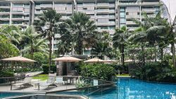 Parvis apartment blocks with outdoor pool, sun loungers, umbrellas and tropical landscaping