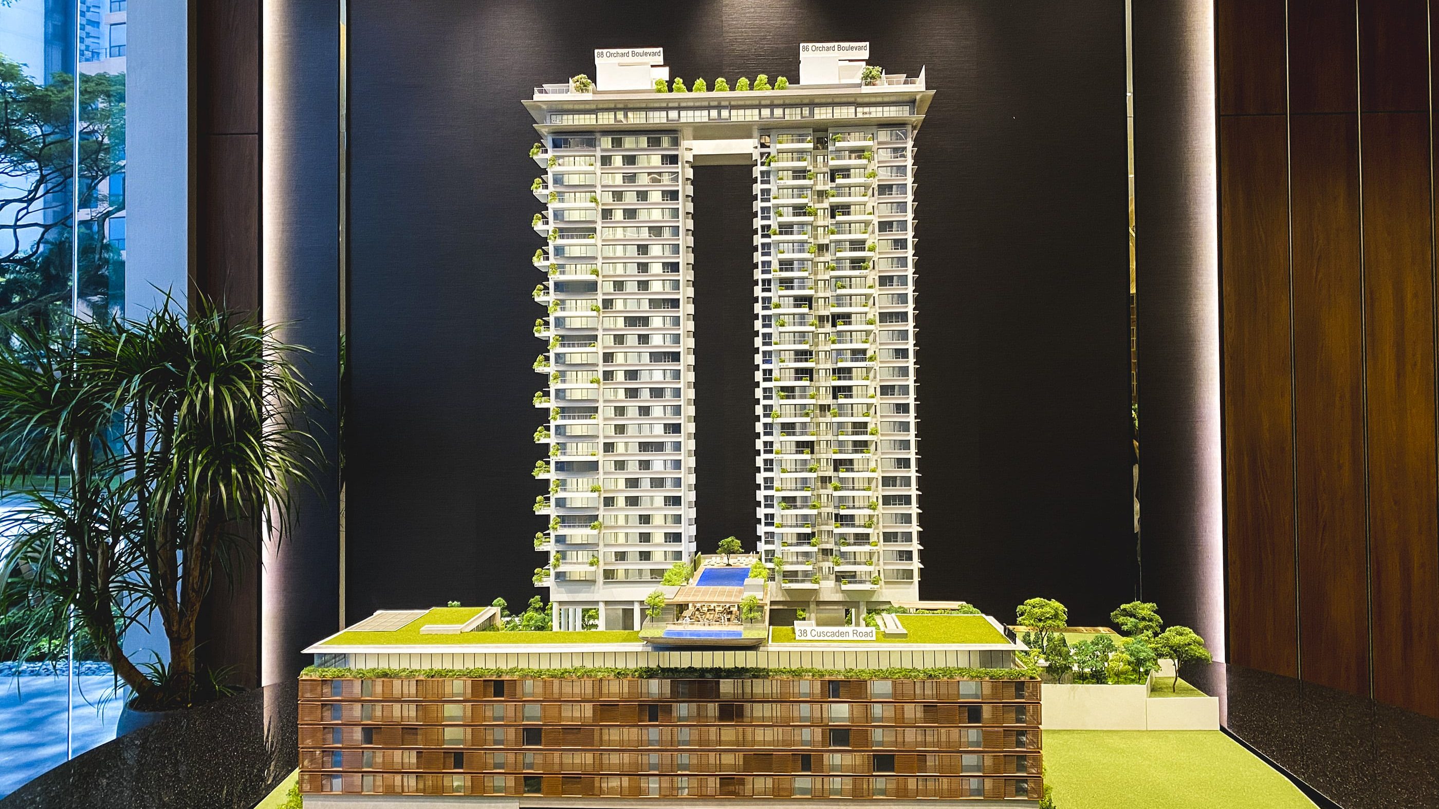 Boulevard 88 architectural model showing two high towers and lower horizontal block with greenery and pool amenities