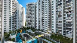 Parkland Residences DBSS blocks surrounding a playground and landscaped garden under clear sky