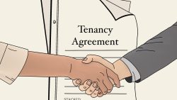 Two people shaking hands over a tenancy agreement document on a clipboard